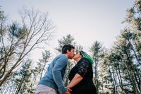 couple kissing in forest at engagement session in Rhode Island