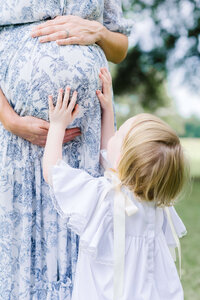 Toddler touching pregnant moms belly