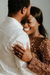A romantic engagement photo of a congolese couple smiling on the beach in Coffs Harbour
