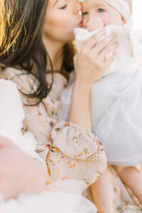 Mom kissing her baby during her family portrait photoshoot