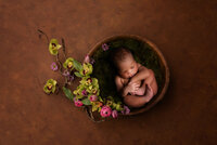 newborn in floral basket