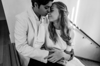 Black and white close-up of Harry and Karolin hugging after their indoor floral arch proposal, captured by Auckland engagement and proposal photographer Zanthe Vorsatz.