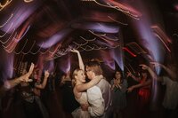 A couple embraces on the dance floor during their wedding at Tanque Verde Ranch in Tucson, Arizona.