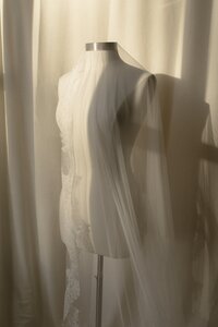 Wedding veil draped on a dress form.