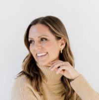 A woman laughing looking to the side.