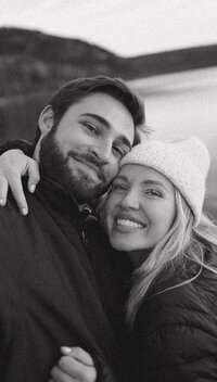 couple hugs in front of water