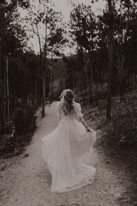 back photo of bride running through the forest at Sapphire Point in Dillon, Colorado