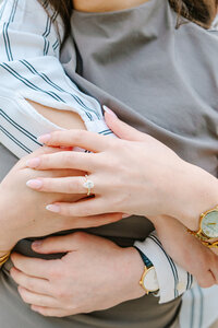 Close-up of man wrapping his arms around woman, showcasing her engagement ring after a Paris proposal at Passerelle Debilly near the Eiffel Tower and Palais de Tokyo.