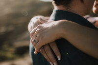 Close-up-of-engagement-ring-around-fiances-shoulders
