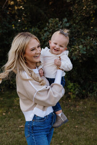 A mom holding her child and smiling