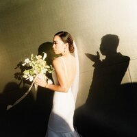 shadow of groom blowing kiss towards bride outside the walt disney concert hall in los angeles