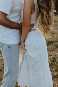 Brunette male hugging his girlfriend from behind