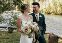 A couple in wedding attire by a river