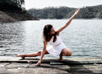 A yogi in a deep side lunge pose, skillfully balancing strength and grace by the tranquil waters, suggesting a blend of vitality and calmness in the practice.