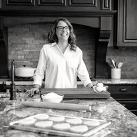 Branding photo for a baker taken in her kitchen standing at the island