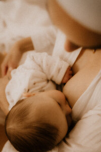 une maman realise des photos en allaitement lors de sa seance photo naissance avec son bebe