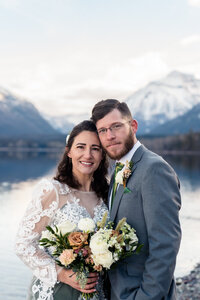 bride and groom posing in front of Lake McDonald.