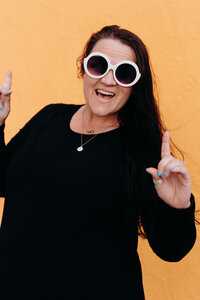 A woman member of the LIVE BIG Collective posing confidently with sunglasses on 