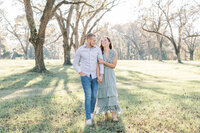 A husband and wife walk through a pecan field.