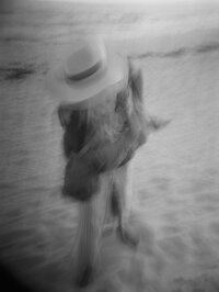 Blurry black and white photo of woman holding her child on the beach