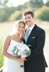 A bride and groom smile for their wedding portrait at a wedding in Michigan