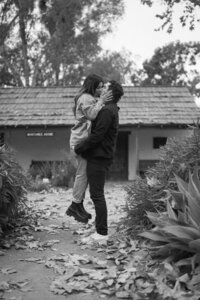 man holding up woman in front of home