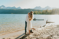 A man holding his girlfriend's hand. She is leaning slightly backwards and they are having fun, laughing a little bit.