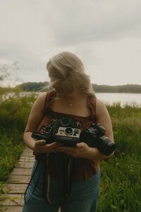 Wedding photographer holding all her cameras while