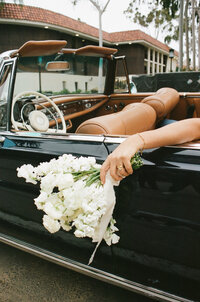 women's bouquet hanging out of car