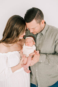 newborn baby girl held by parents  by Springfield MO newborn photographer The XO Photography
