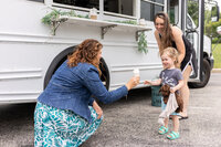 Rachel serving a little boy a kid-friendly hot chocolate