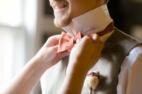 Woman straitening grooms bow tie