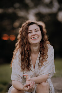 Girl with wavy brown hair smiling at the camera