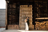 bride and groom posing in front of  tall wooden door
