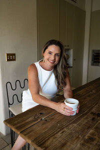 Castilia smiling in a cozy home setting, parent coach and founder of Raising Our Future.