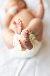 Newborn boy wrapped in egg shell blue color  during his first portrait session.
