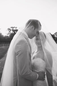 A couple underneath the bride's veil close together during their wedding in Orlando, FL