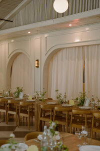 Photo of long reception table with arched wall in the background
