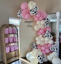 pink and cow print balloon decor for baby shower