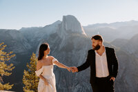 Married couple in front of half dome in Yosemite National Park at sunrise