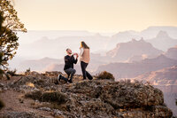 A woman’s surprised expression as her partner proposes at the iconic South Rim of the Grand Canyon.