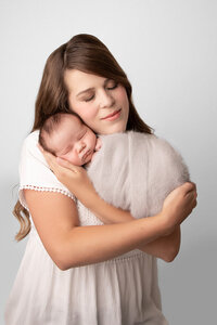 mother holding her swaddled newborn baby