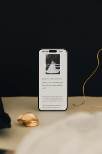Editorial Showit website template on phone screen featuring a classic bridal portrait, perfect for modern wedding photographers.