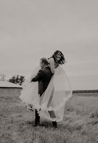 groom picking up bride over his shoulder