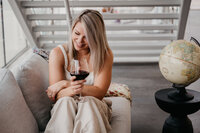 woman on a couch with a glass of wine