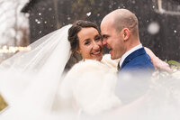 bride-and-groom-laughing-in-snow-at-barn-wedding-jorgensen-ohio