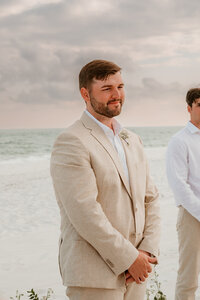 Groom looking at his wife walking down the isle during a Pensacola Beach Wedding-Elopement-photographer-micro-wedding-destination-photographer-couples-picture