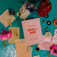 Wedding invitations and flowers laid out on a table.