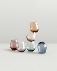 Elegant arrangement of colorful glass tumblers, artistically stacked and balanced, styled by Ylva Erevall.