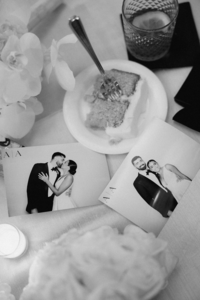 Flat lay of wedding photos, a slice of wedding cake, florals, and a drink in true documentary style | Sush Digital Media